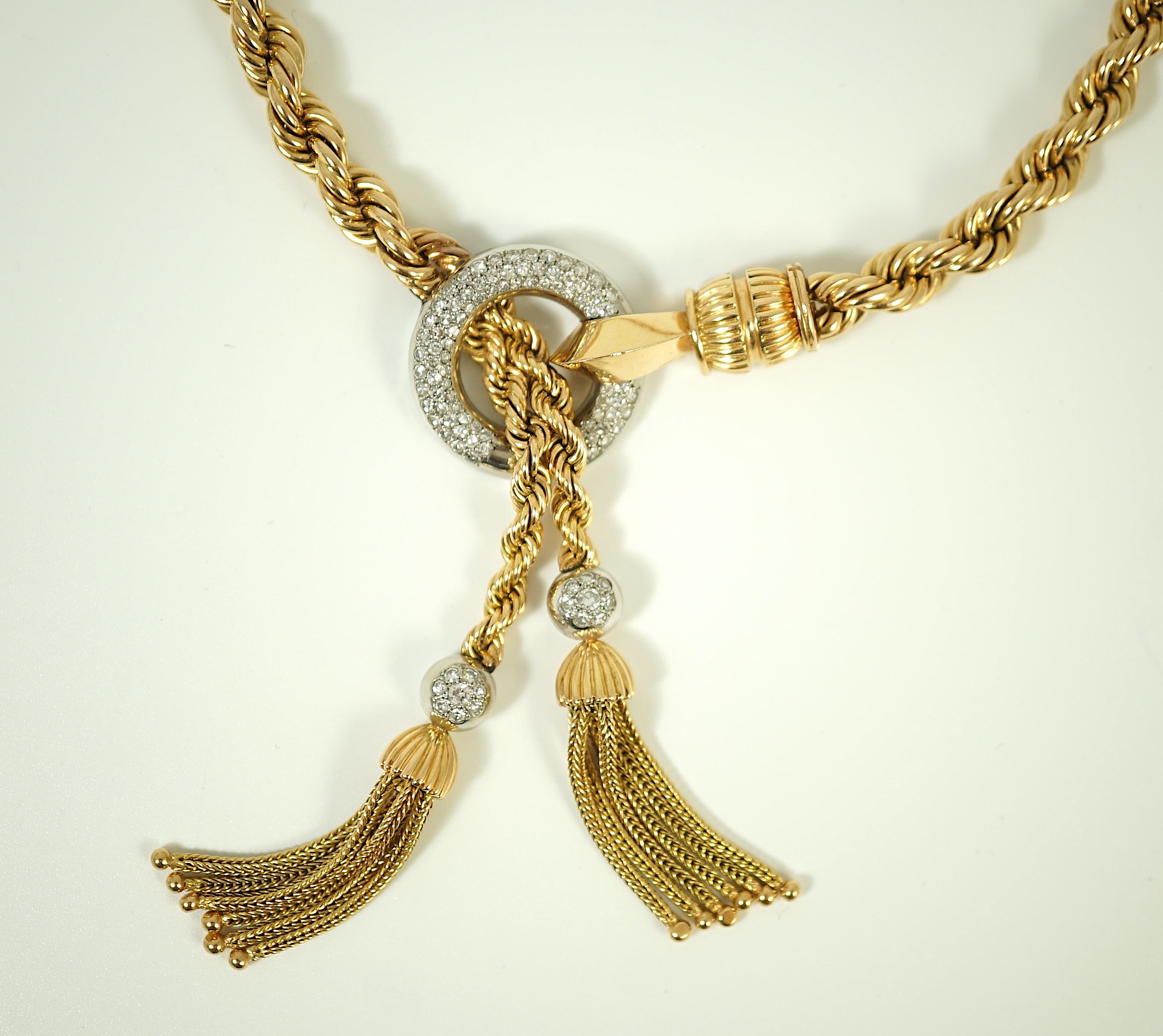 A modern heavy Middle Eastern gold and diamond set rope twist drop tassel necklace, together with a similar gold and diamond set bracelet